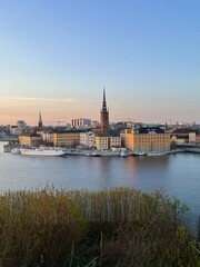 Obraz premium Evening View of Riddarholmen Island in Stockholm, Sweden. Riddarholmen Church, scandinavian architecture. Black roofs of the old town and ships on the embankment.