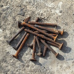 Aged rusty nails on concrete, symbolic of industrial history and decay