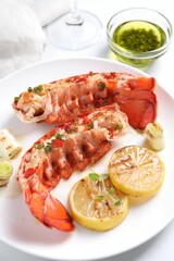 Delicious lobster tails with lemon, microgreens and green onion on white table, above view