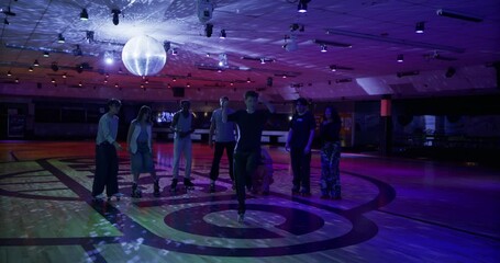 Young man doing epic ballerina spin in front of friends in disco themed room - cinematic slow motion