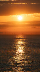Beautiful golden sunset over the ocean. Vertical background image.