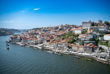 Obraz premium Wide angle cityscape of Porto, Portugal on a bright sunny day with blue sky., looking over the river Douro.