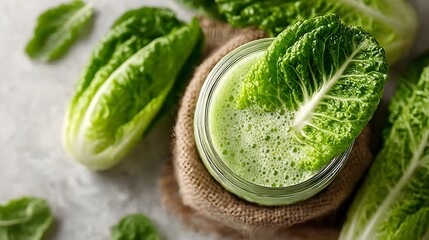 Obraz premium A refreshing green smoothie made with romaine lettuce and spinach in a mason jar sits on burlap.