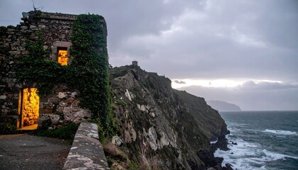 Coastline view, light pouring from rustic stone building, overcast sky