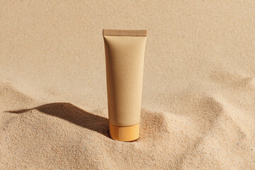 Sunscreen tube resting on sandy beach at midday