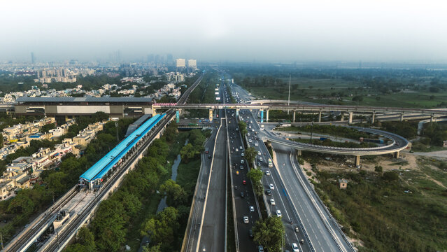 Top down cross traffic highway with cars, trucks aerial. Urban transportation at bridge road at Delhi. Cinematic cityscape of downtown freeway drone shot. Noida Freeway.