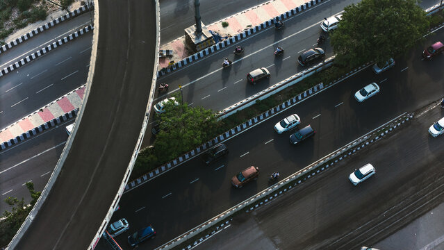 Top down cross traffic highway with cars, trucks aerial. Urban transportation at bridge road at Delhi. Cinematic cityscape of downtown freeway drone shot. Noida Freeway.