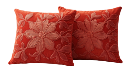 Two coral-toned velvet throw pillows with embossed floral designs; a light peach floral pattern stands out against the darker background