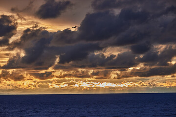 Obraz premium A dramatic stormy sky looms over the vast expanse of Lake Titicaca, casting deep shadows and rich blues across the high-altitude landscape.