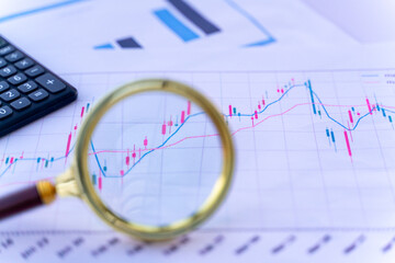 Financial-themed charts, magnifying glass, gold coins, calculator, house model