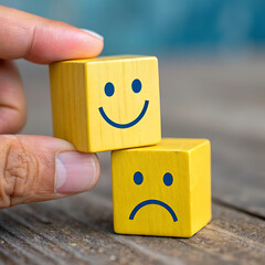 Customer service evaluation, feedback, rating, client experience, and satisfaction survey concepts. The businessman's hand chooses the happy smile face icon on yello cube on table.