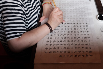 Buddhist believers copying Buddhist scriptures in the temple