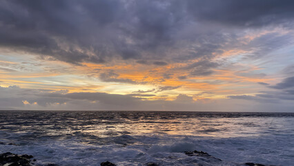 Obraz premium Dramatic Ocean Sunset Fiery Hues and Stormy Cloudscape