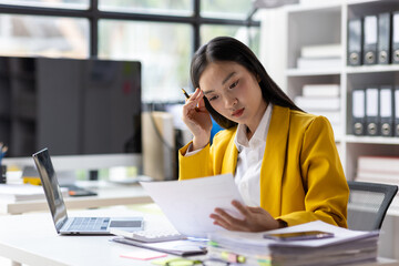 Serious female accountant working with financial documents in office and auditing accounts. Auditor...