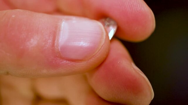 gemstones on a white table in multicolor illumination, A man's hand holds the jewels