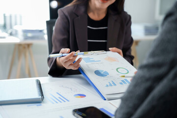 Business team working with financial data analyzing charts and graphs discussing company performance