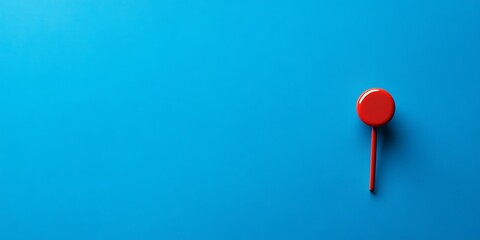 Vibrant red marker on a bold blue background, symbolizing a precise location or a focal point in an abstract, minimalist composition