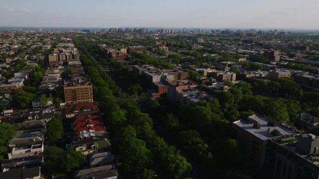 Aerial view of a residential neighborhood in Brooklyn, New York City, captured on a clear spring day. The image features mid-rise apartment buildings, tree-lined blocks, and dense housing patterns ext
