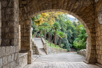 A stone porch with graceful openwork arches decorates the facade of an old historical building where the restaurant "Gagripsh" is located in the city of Gagra.
