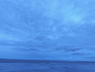 The sky is cloudy and the ocean is calm, Calm ocean waves rolling onto sandy beach under cloudy sky scenic view from above nature landscape seascape coastal scene