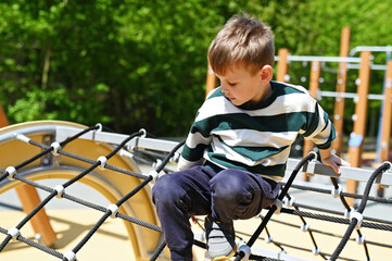 Kid boy climbing on playground 