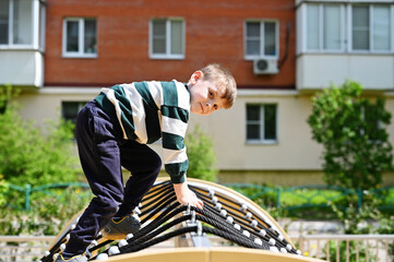 Kid boy climbing on playground 