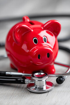  Red piggy bank and stethoscope symbolizing health savings, medical insurance planning, and financial wellness for healthcare