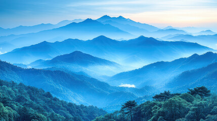 Obraz premium Breathtaking mountain silhouette at dawn, showcasing layers of blue hues and misty valleys, evoking sense of tranquility and wonder