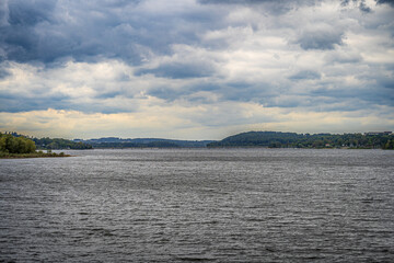 Der Möhnesee zeigt sich hier von seiner dramatischen Seite, mit einem Himmel, der Geschichten erzählt. Die dunklen Wolken spiegeln sich im bewegten Wasser und verleihen der Szene eine ganz eigene Ruhe