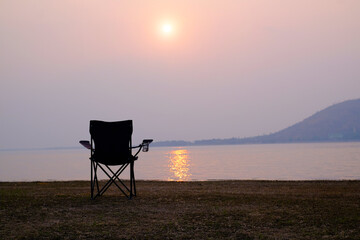 Camping chair with lake view and sunset