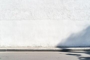 Blank white wall with curb and shadow