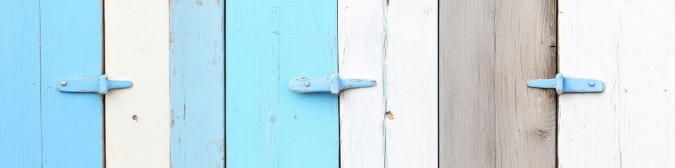 Close-up of weathered wooden planks, painted in varying shades of blue, white, and gray, with simple metal latches