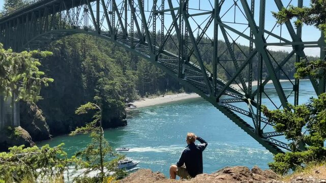 Man at Deception Pass bridge, a strait separating Whidbey Island from Fidalgo Island, in the northwest part of Washington. It connects Skagit Bay, part of Puget Sound, with the Strait of Juan de Fuca.