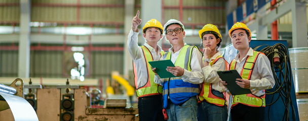 Fototapeta premium Factory apprenticeship. Header mentor teaching young employees trainee operating machine looking monitor and check Production process machinery. foreman explaining team engineer control machine