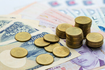 Scattered coins on various bank notes from different currencies creating a vibrant money display