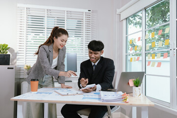 Business professionals analyzing investment graphs and financial charts on laptops during a strategic meeting in a modern office environment.