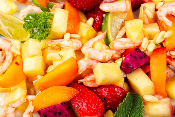 Fresh shrimp salad with colorful fruits.
