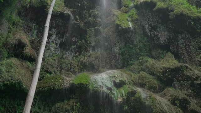 Tumalog falls tilt down and pan across at 60fps showing the otherworldly limestone formations of the rocks at Tumalog falls.