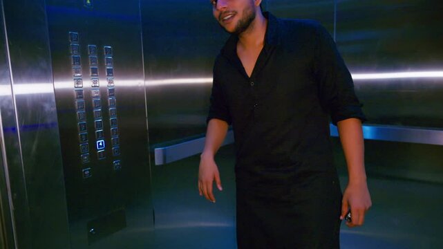 Muslim man taps lift panel in silent confusion