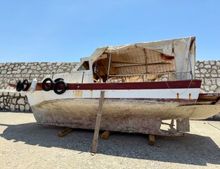 An old, worn-out boat with a rusty, muddy bottom resting on the shore. A reminder of the past...