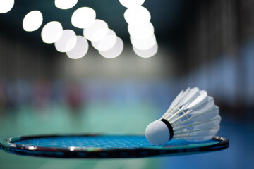 Badminton shuttlecock on badminton racket background in competition field