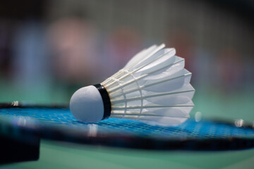 Badminton shuttlecock on badminton racket background in competition field