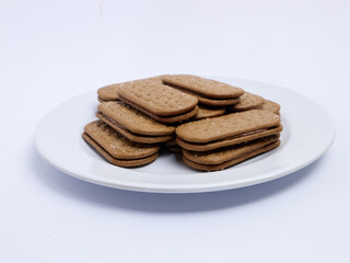 Stack of rectangular biscuits with sugar topping neatly arranged on a white plate, isolated on a white background