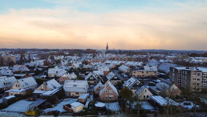 Winter aerial shot of houses with solar panels snow on roof during winter. Street in a residential area neighborhood in The Netherlands.