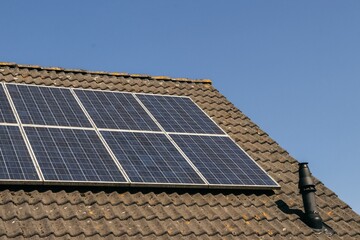 Solar panels on roof. Close up side view. Green clean energy, sustainability, eco-friendly technology powered by the sun. Renewable energy solutions building house neighborhood.