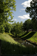 Canal river in summer landscape view. Fresh grass stadswallen with trees horizontal photo.