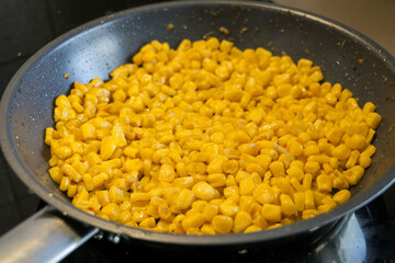 Corn cooking in pan. Preparing dinner lunch recipe food. Ingredients preparation baking frying snack.