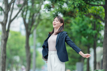 運動　リフレッシュ　ビジネス　女性　新緑　深呼吸
