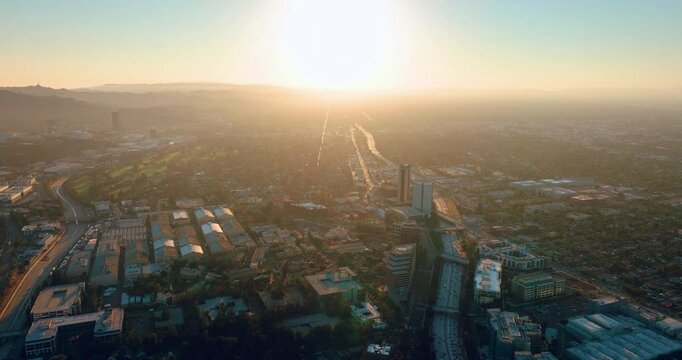 Panorama of the city of Los Angeles at sunset. Aerial view of residential neighborhoods and the interstate. Rooftops of houses and film studios in the Burbank area.
