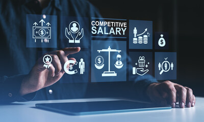 Fototapeta premium Businessman interacting with digital icons representing competitive salary and employee benefits on a futuristic interface in dark environment.